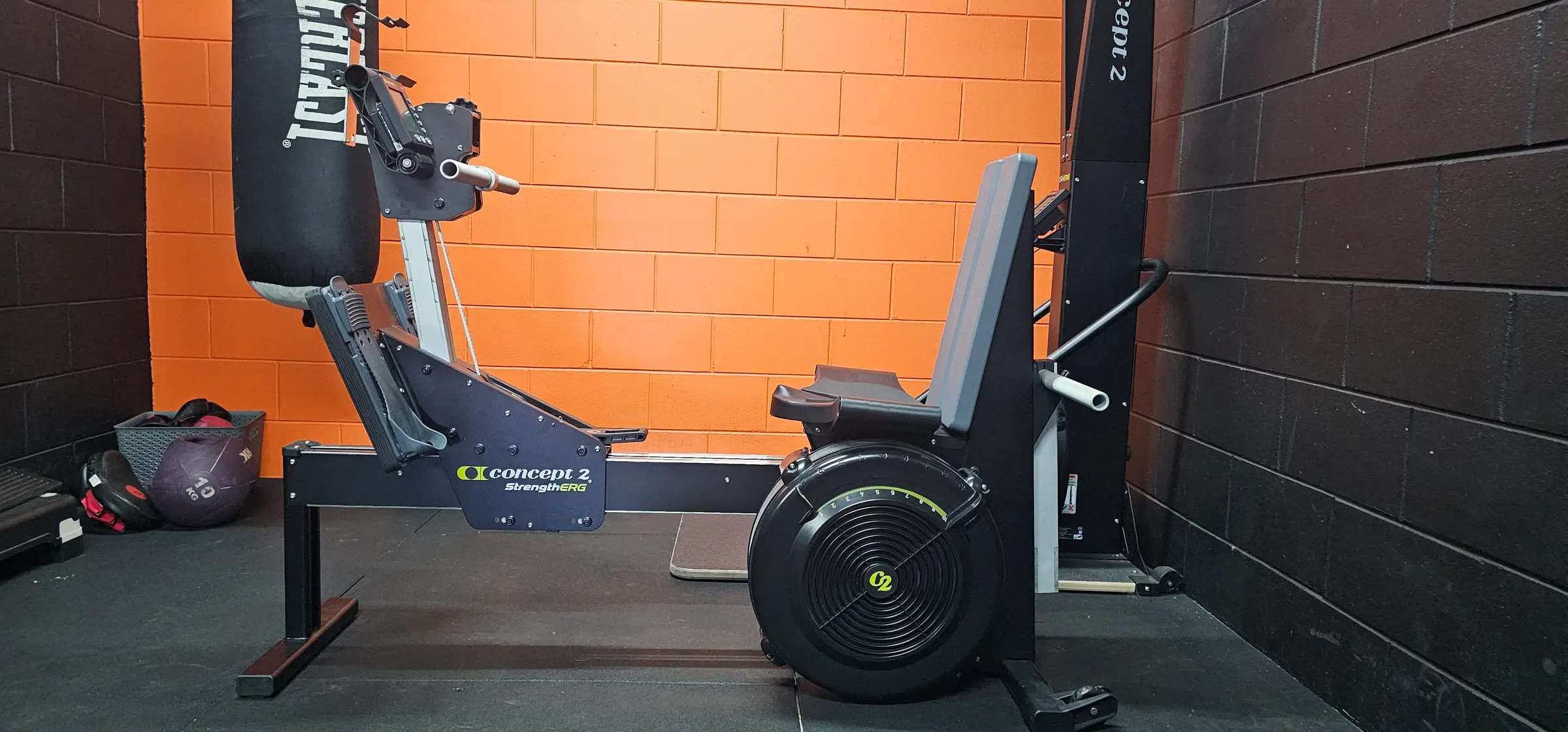 The conditioning corner at Get Fit Burdekin: a Concept2 StrengthERG under a hanging Everlast boxing bag, against the orange wall