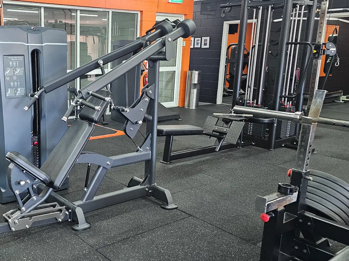A pin-loaded incline chest and shoulder press machine on the main floor at Get Fit Burdekin, with a bench behind it