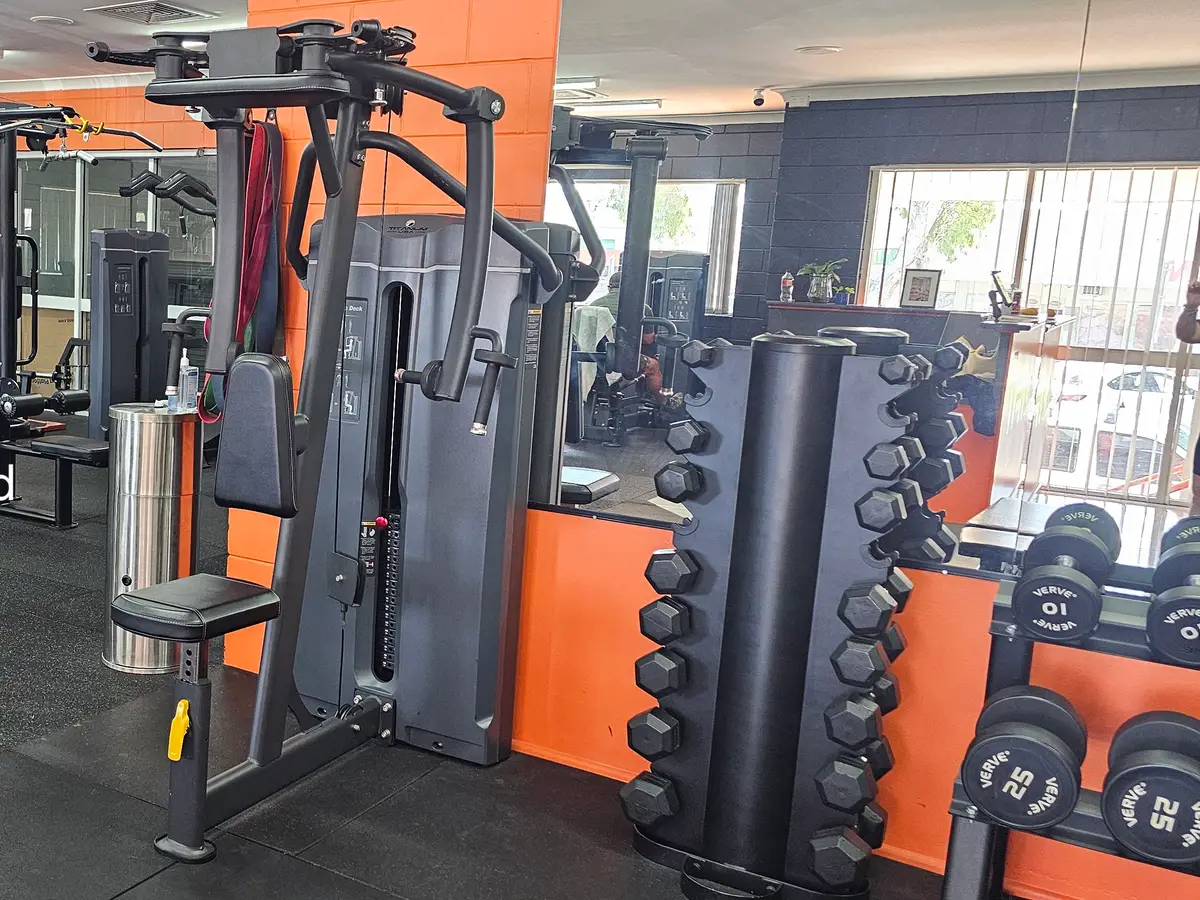 A pin-loaded pec deck and rear delt fly machine beside a dumbbell tower at Get Fit Burdekin