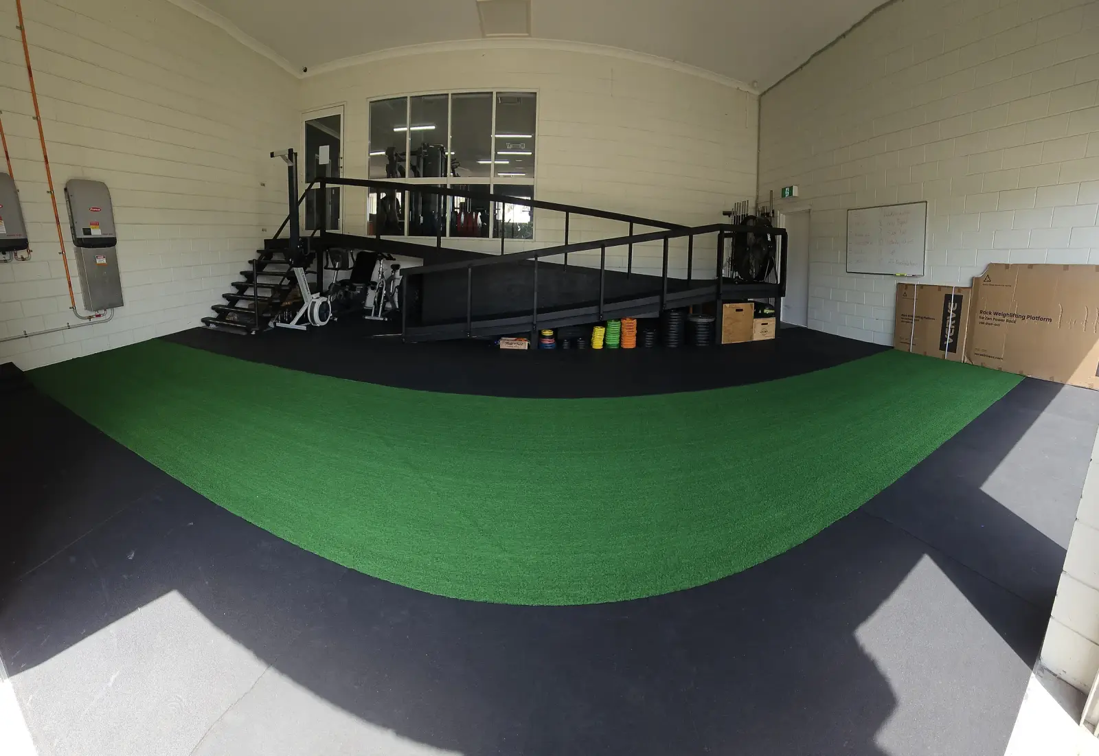 The group fitness area at Get Fit Burdekin, a green turf strip curving towards the raised platform with stairs