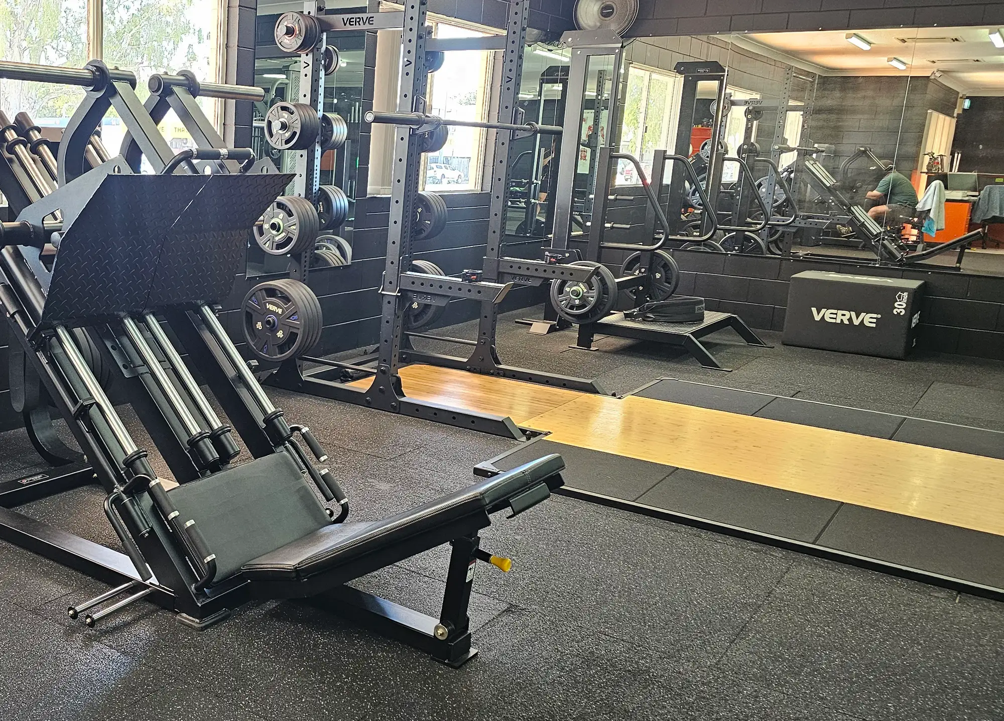 A plate-loaded leg press in front of the squat racks and lifting platform under the front windows at Get Fit Burdekin