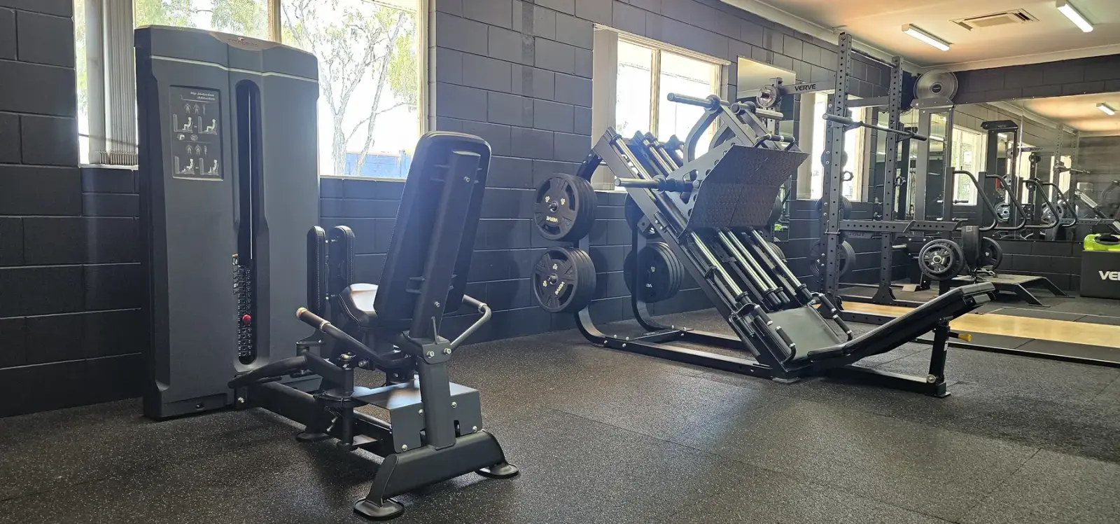 The window wall at Get Fit Burdekin: a hip abduction machine, a plate-loaded leg press and squat racks running down the room