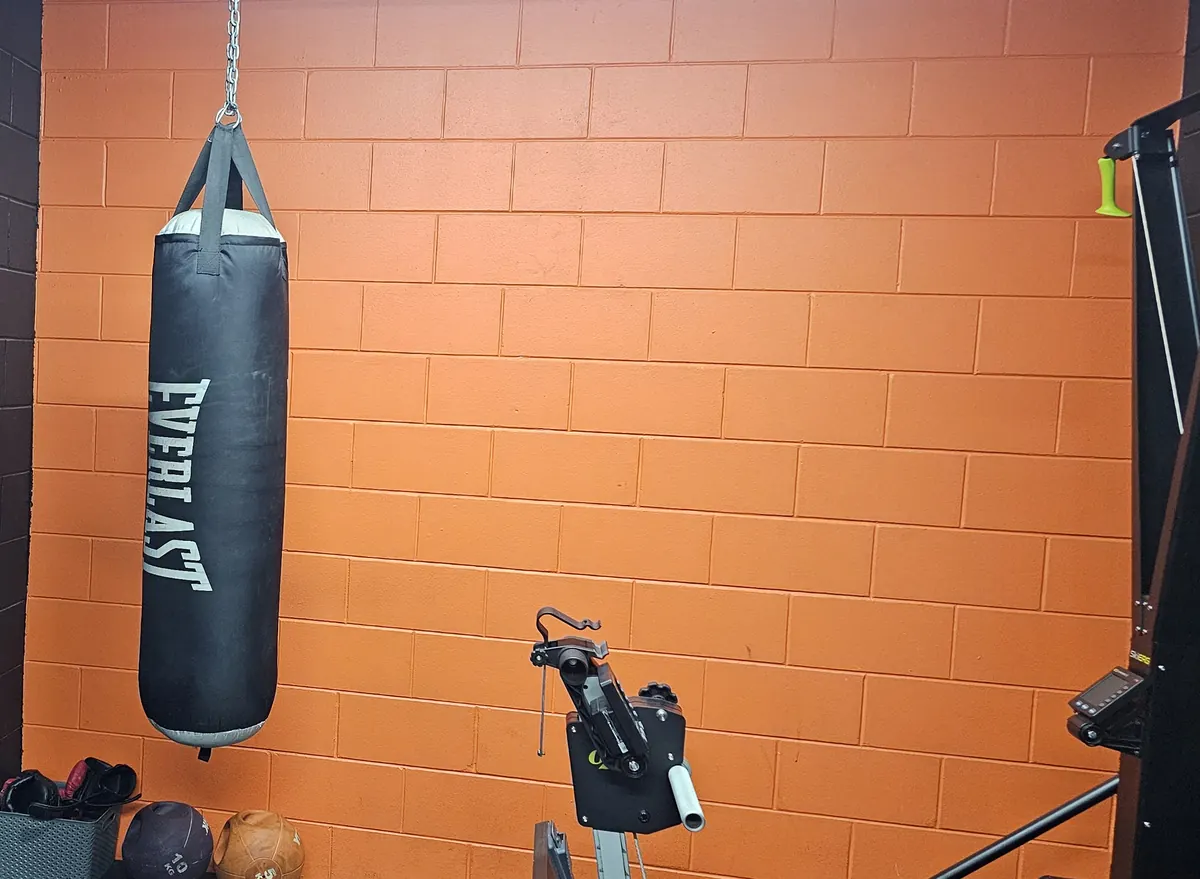 An Everlast boxing bag hanging against the orange brick wall at Get Fit Burdekin
