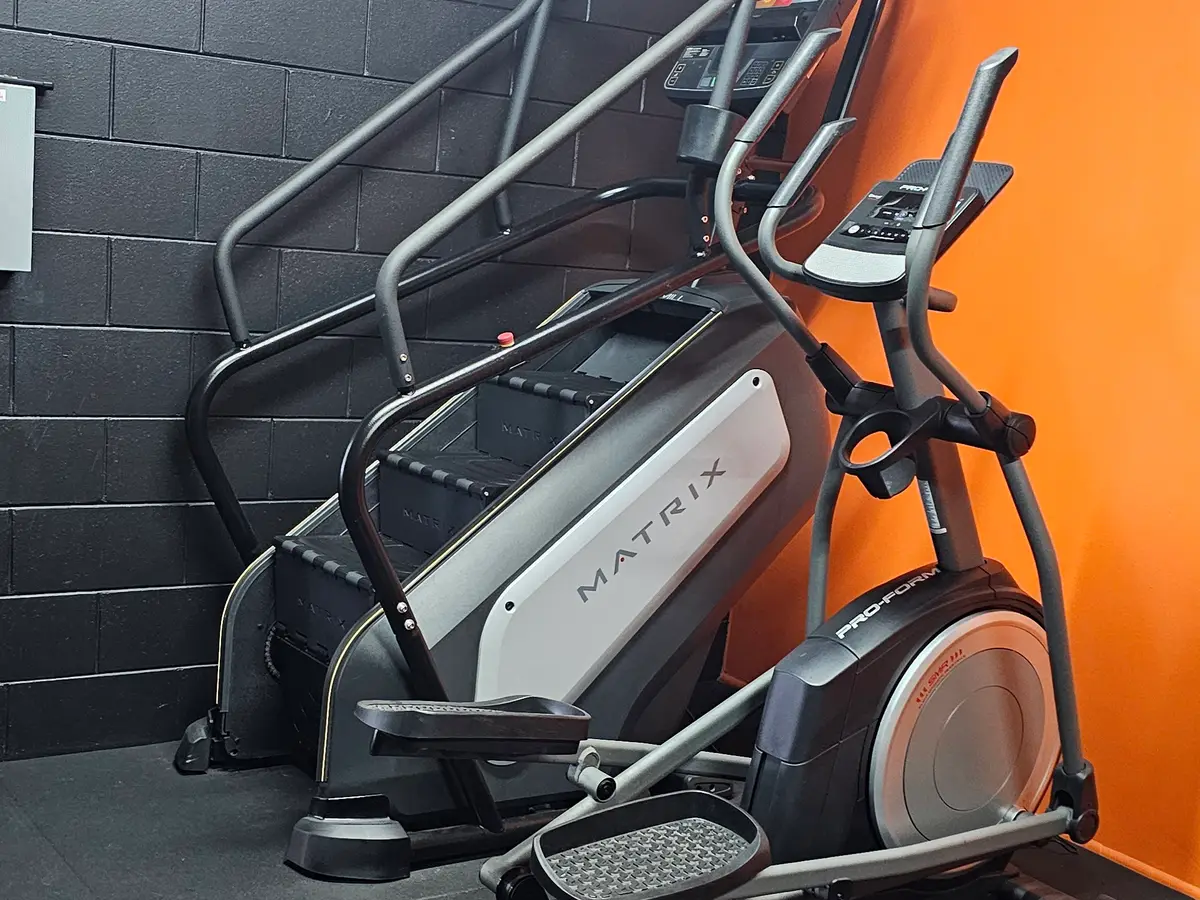 An elliptical cross-trainer against the orange wall of the cardio room at Get Fit Burdekin