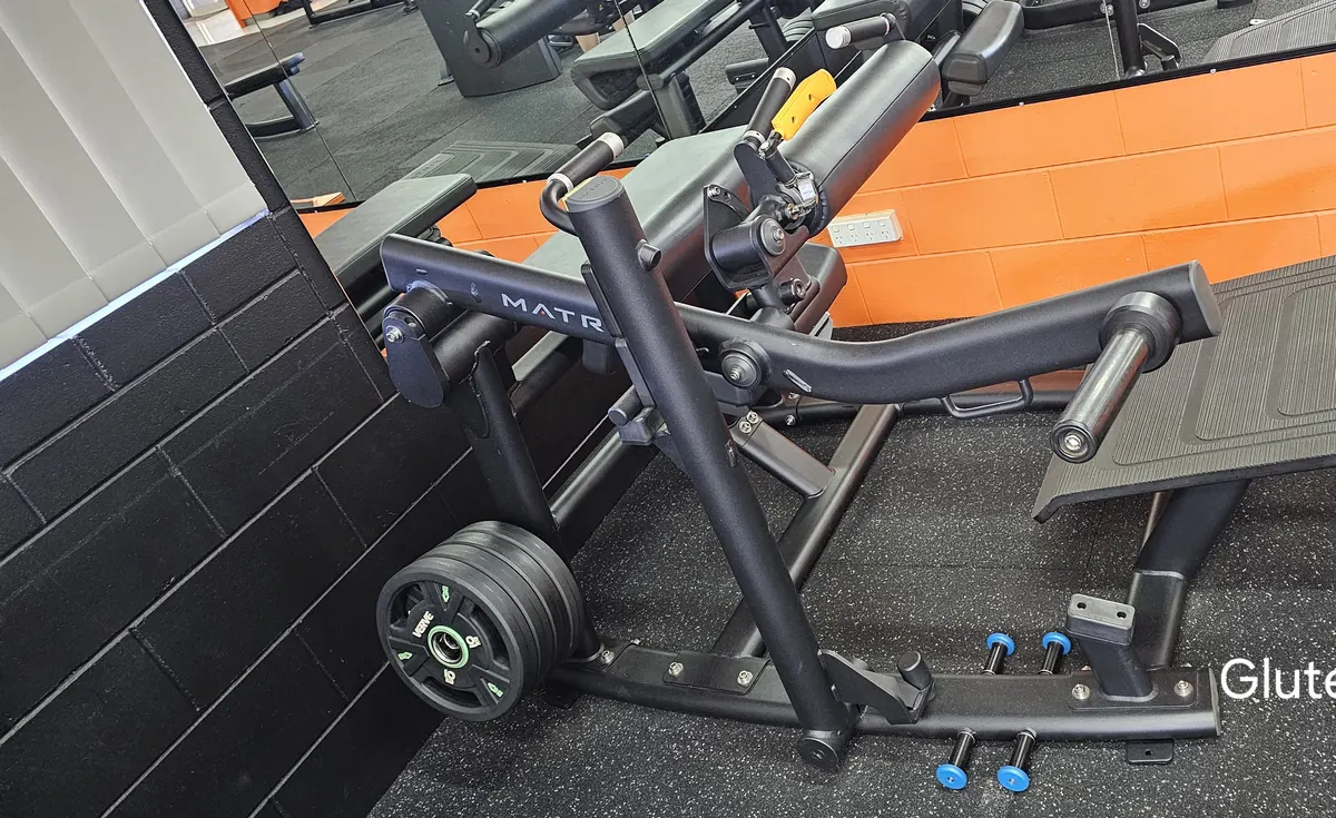 A Matrix plate-loaded glute trainer against the orange wall at Get Fit Burdekin
