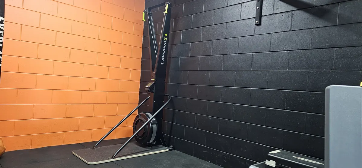 A Concept2 ski erg standing against the black brick wall at Get Fit Burdekin