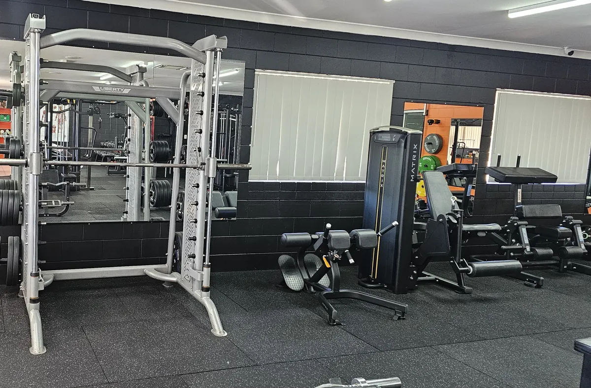 A Smith machine in front of the mirrored wall at Get Fit Burdekin, with leg machines beside it