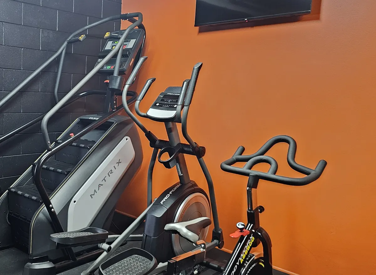 A Matrix stairmill in the corner of the cardio room at Get Fit Burdekin, with an elliptical and spin bike beside it