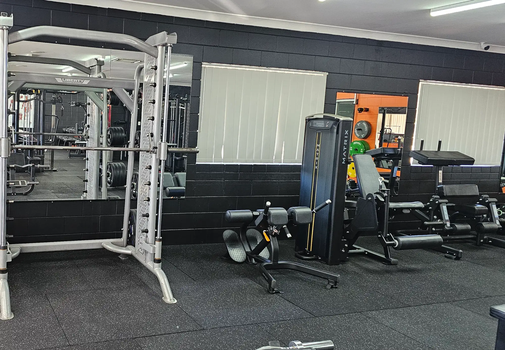 A Smith machine in front of the mirrored wall at Get Fit Burdekin, with leg machines and a cable station beside it