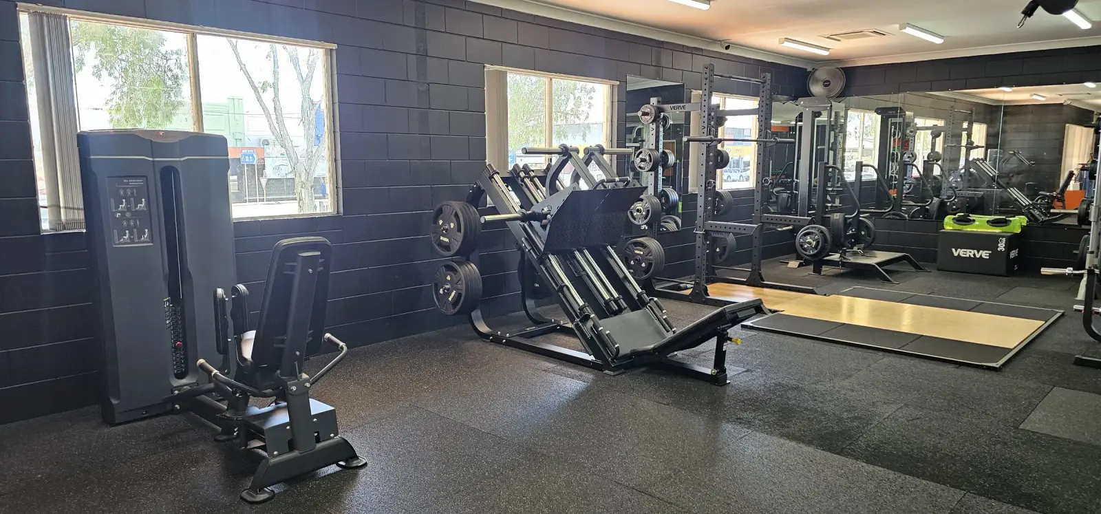 The weights floor at Get Fit Burdekin in Home Hill, with a leg press, hip abduction machine and squat racks along the window wall